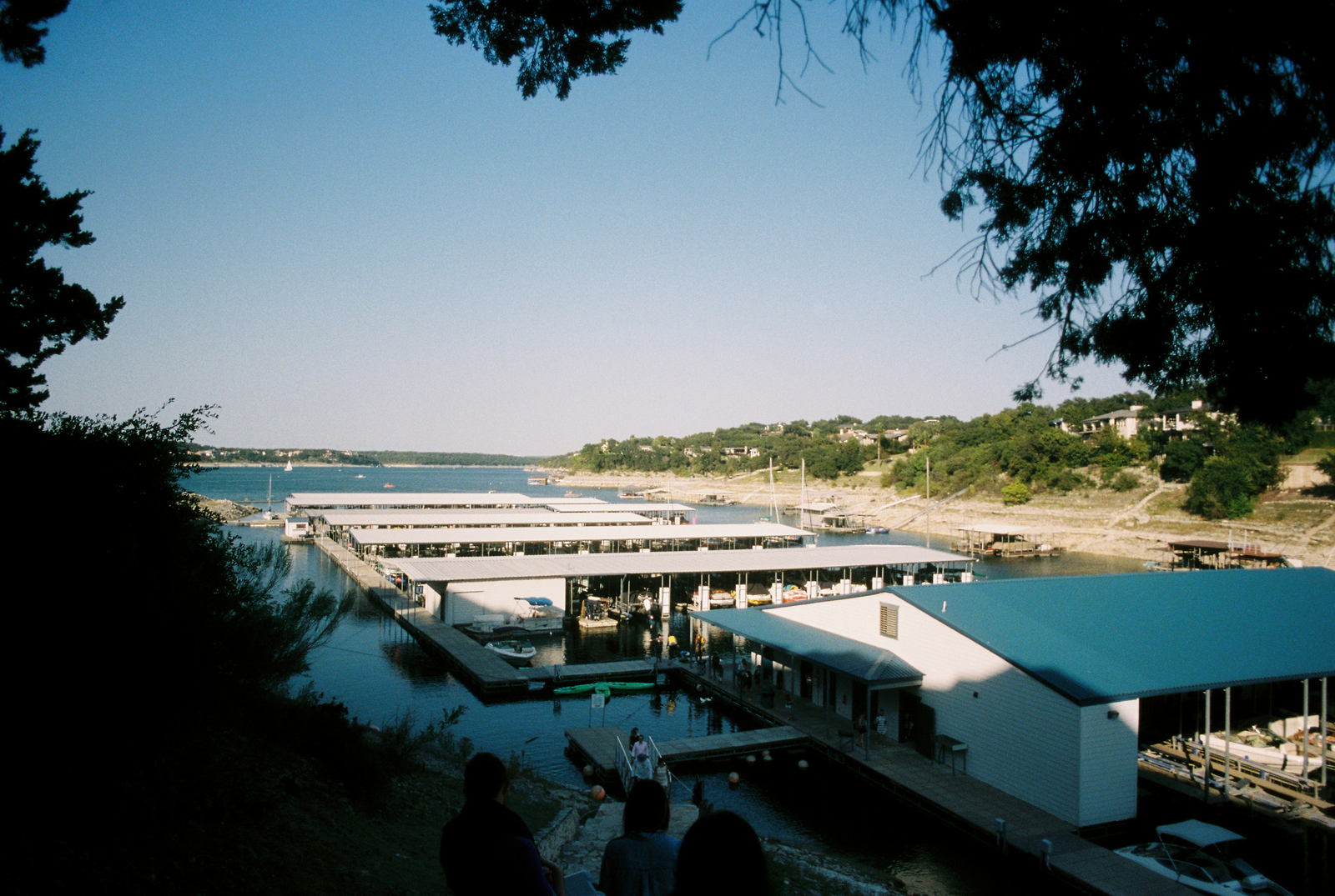 Boat cruising on a sunlit lake with houses along the shoreline