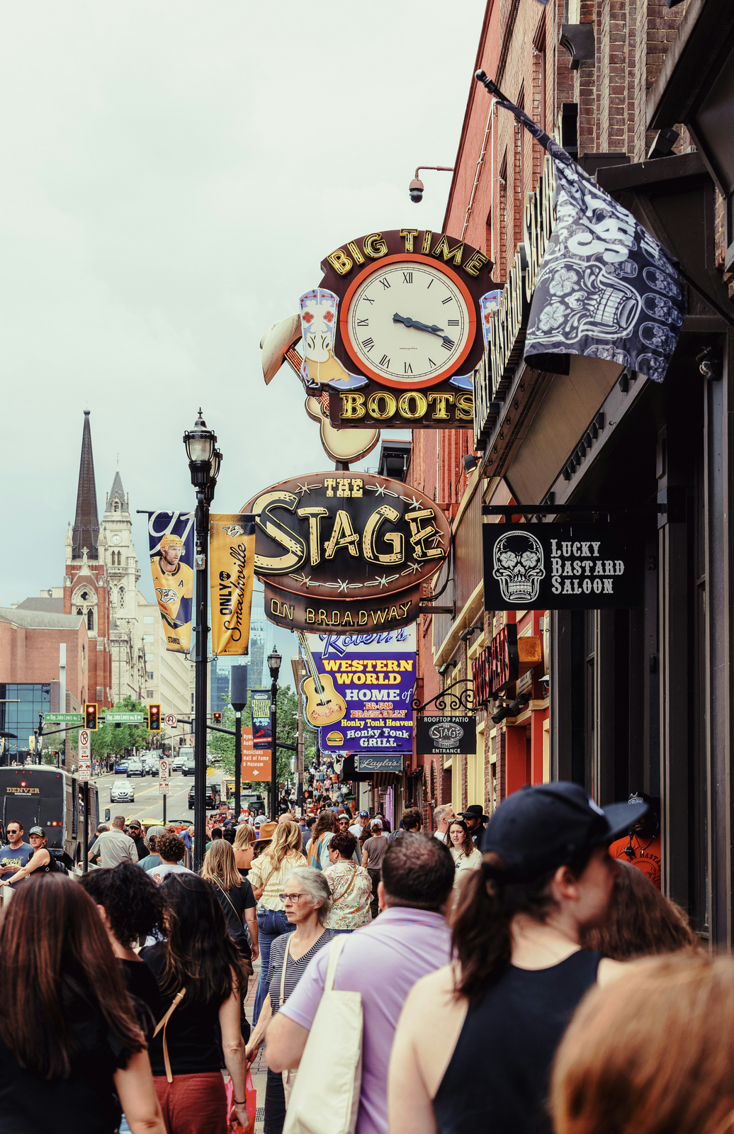 Broadway street in Nashville lined with honky-tonk bar signs and crowds