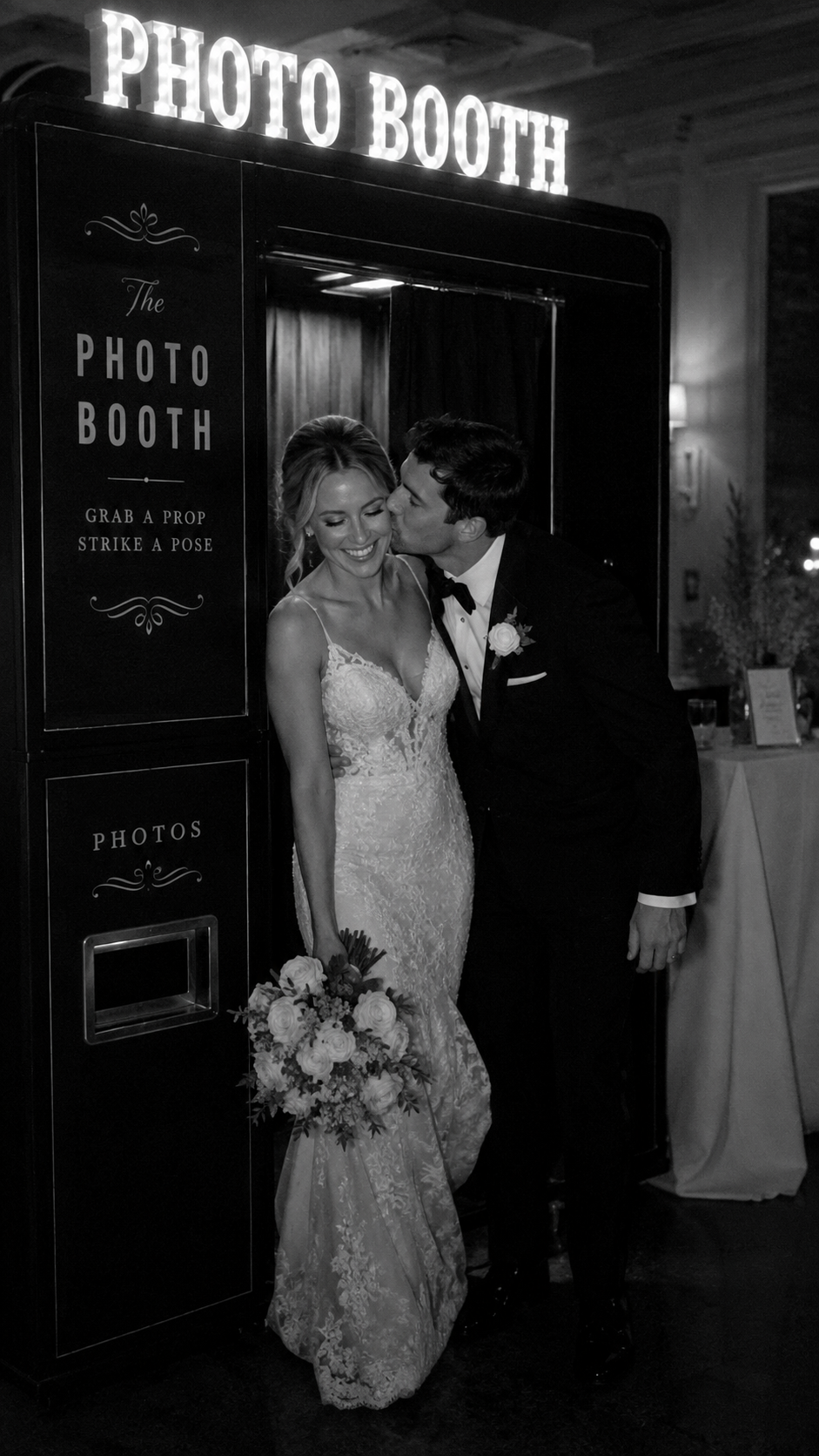 Bride and groom kissing outside a wedding reception photo booth