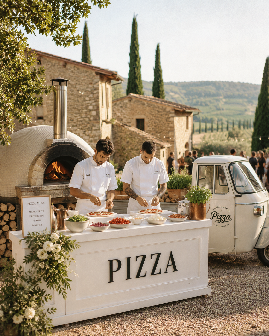 Wood-fired pizza catering station at an outdoor wedding reception